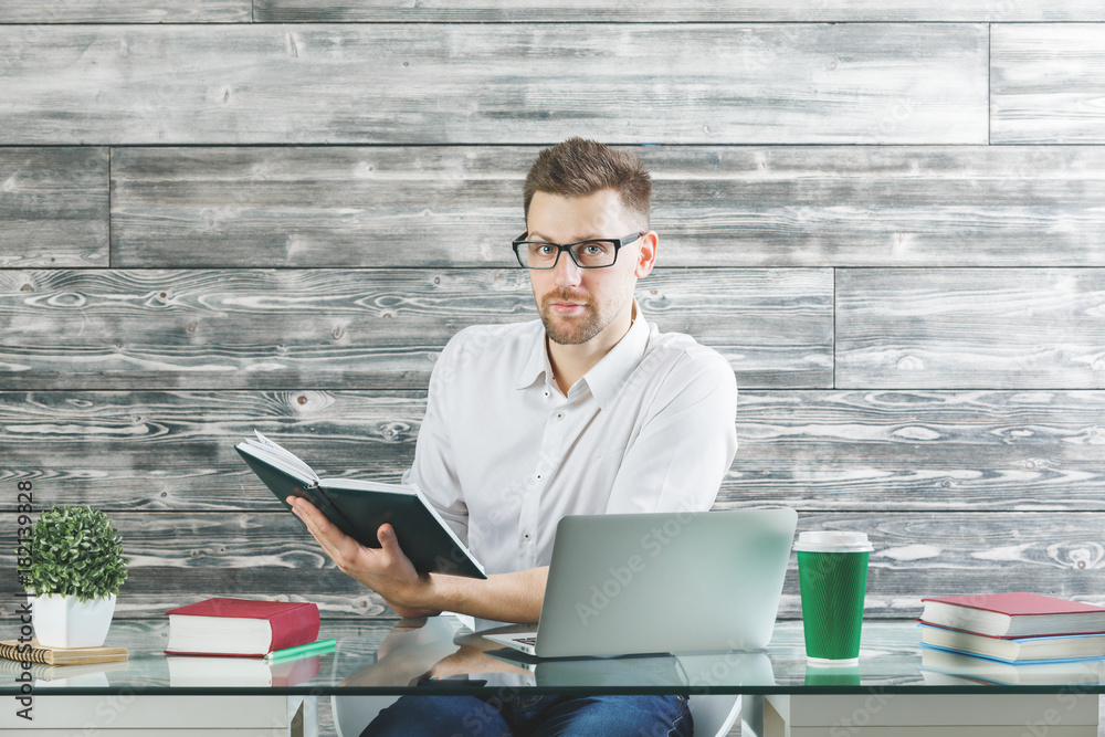 Wall mural man reading book in office