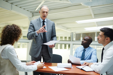 Senior employer making report about successful development of the company and further financial increase