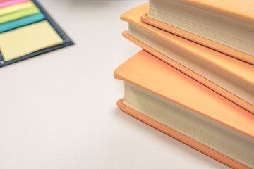 Stack of books with yellow book covers on white background with colorful note papers on white background, office or school work concept