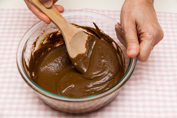 Hand preparing mixing grounded traditional medicine Chinese herbs with ladle