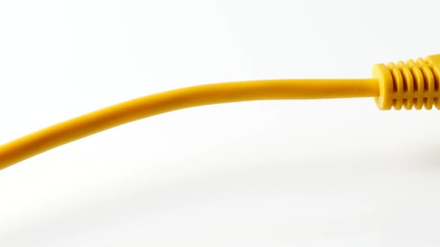 closeup of yellow network cable connected to laptop, panning