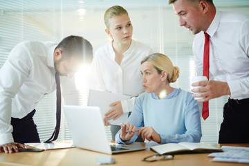 Mature employer discussing possible difficulties of getting online statistics with her subordinates