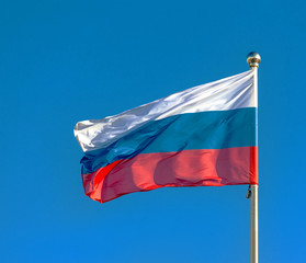 Russian flag on a background blue sky.