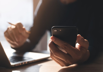 Man working on laptop computer and smartphone