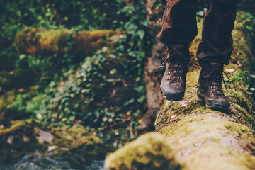Man Traveler crossing over river on woods outdoor in wild forest Lifestyle Travel extreme survival...
