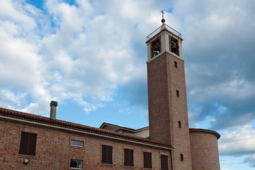 The back side of the ancient church with the bell tower in Marotta, Italy