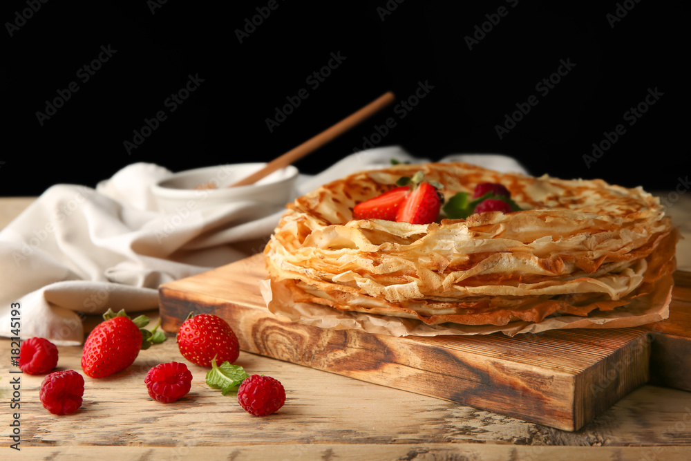 Canvas Prints Delicious thin pancakes with berries on wooden board