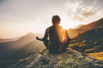 Man meditating yoga at sunset mountains Travel Lifestyle relaxation emotional concept adventure summer vacations outdoor harmony with nature - obrazy, fototapety, plakaty