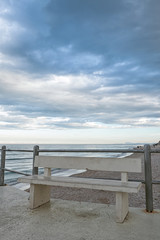 Fototapeta na wymiar The viewpoint on the beach with bench of Marotta under a cloudy sky, Italy