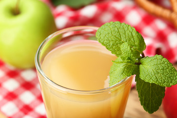 Glass with fresh apple juice on table, close up