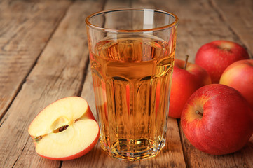 Glass with fresh apple juice on wooden table