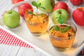 Glasses with fresh apple juice on tray