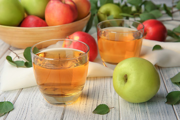 Glasses with fresh apple juice on wooden table