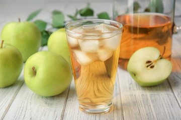 Glass with fresh apple juice on wooden table