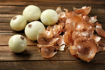 Raw peeled onion on wooden background