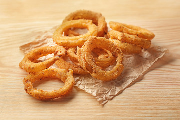 Fried breaded onion rings on wooden background