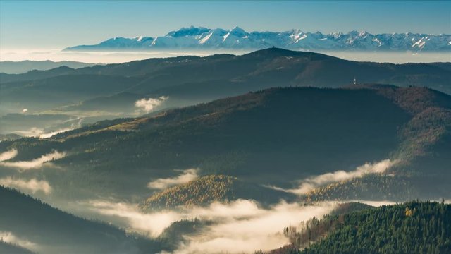 Mists in Carpathian mountains, snowy Tatra in the background, timelapse, Poland landscape