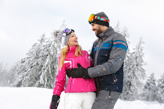 Cheerful man and woman in love in snowy nature