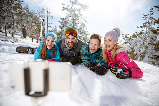 Happy family on skiing taking selfie on snow