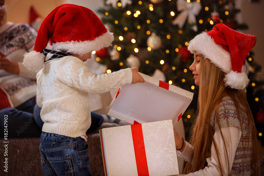 Wall mural Happy Christmas - Kids opening Christmas gift.