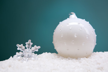 Christmas card - white and glass balls and Christmas toys on a snow slide. Close-up, beautiful picture.