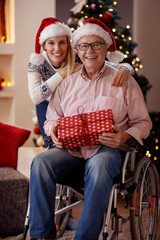 portrait of daughter and elderly father in wheelchair on Christmas.