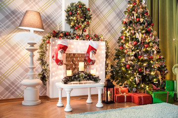 New year green tree decorated with presents and flashing garland, classic white christmas interior background.