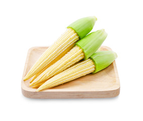 Fresh baby corns in wooden dish.