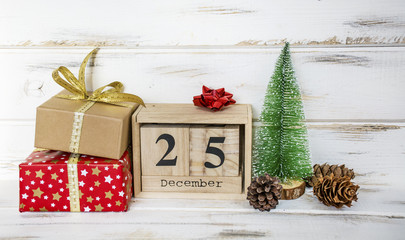 Christmas Gifts and Wooden Calendar with Date on White Wooden Background. Christmas Concept