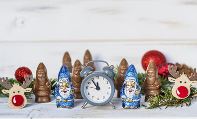 Chocolate Santa Claus and New Year's Alarm Clock.  Celebration Concept for New Year Eve and Christmas.