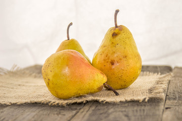 Tasty, juicy, ripe, yellow pears on a rustic background on a wooden table and a white background.