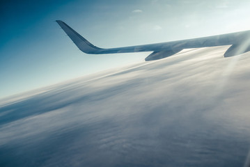 Fototapeta na wymiar Airplain wing view thrue porthole in the sky