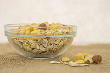 A healthy muesli breakfast with dried fruits in a bowl on a rustic jute base