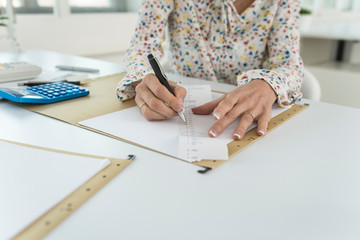 Accountant summing up the numbers writing on a printout receipt