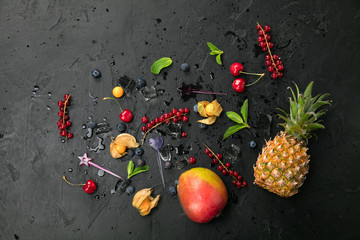 Group of fresh juisy berries and ice cubes on black background. Top view with copy space. Healthy Food Backgrounds