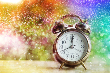 alarm clock showing midnight on New Year or Christmas day with colorful abstract bokeh , glitter...