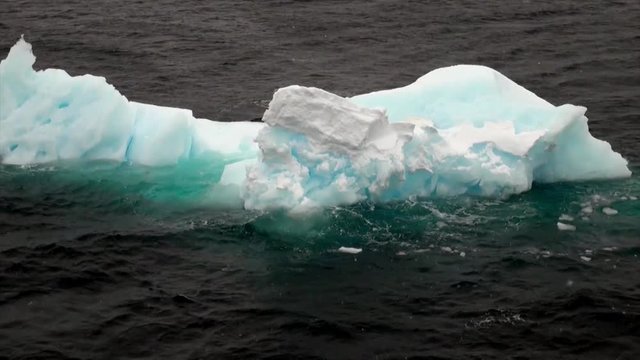 Icy desert of ocean in Antarctica. Glacier on background of snow mountains.Travel in calm and silence of cold polar north. Scenic blue water. Global warming. Unique nature of desert . Wilderness area.