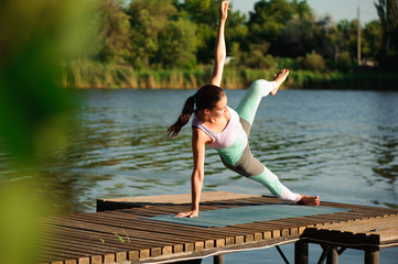Fototapeta na wymiar Young woman doing yoga in morning park