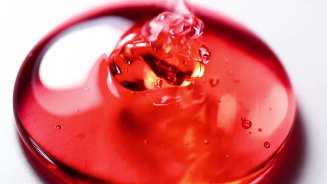 Pouring liquid Red Honey Dripping on White Surface Close Up Macro