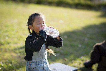ペットボトルの水を飲むリトルガール