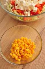 Sliced salad of corn and cabbage with tomato and feta cheese