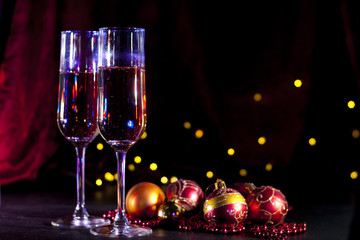 two champagne glasses with christmas lights and decorations