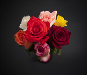 Bouquet of colorful roses on black background, top view