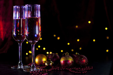 two champagne glasses with christmas lights and decorations