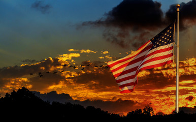 Obraz premium American flag na maszt macha na wietrze American flag przed jasnym niebie