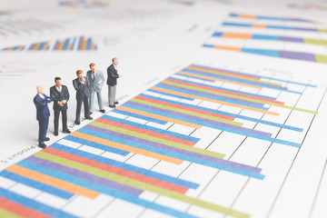 Miniature People : Businessman standing on a Paper graph chart ,Developing a teamwork concept