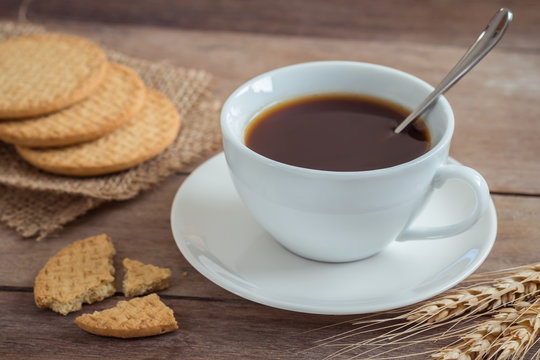 Cup of coffee and crackers on wooden table