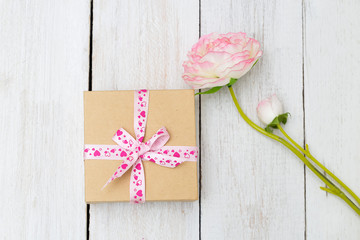 Gift box with ribbon and rose on wooden table for Valentines day