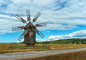 Ancient wooden mill in autumn field. Ukraine, Kiev, Porogovo