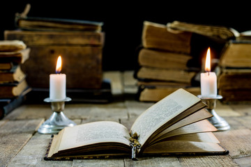 Old books and candles on a wooden table. Old room, reading room.